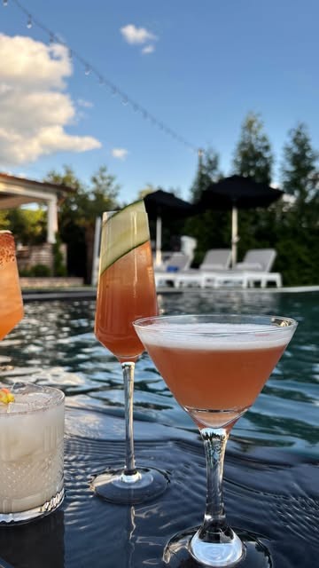 Two cocktails on the edge of a pool at dusk