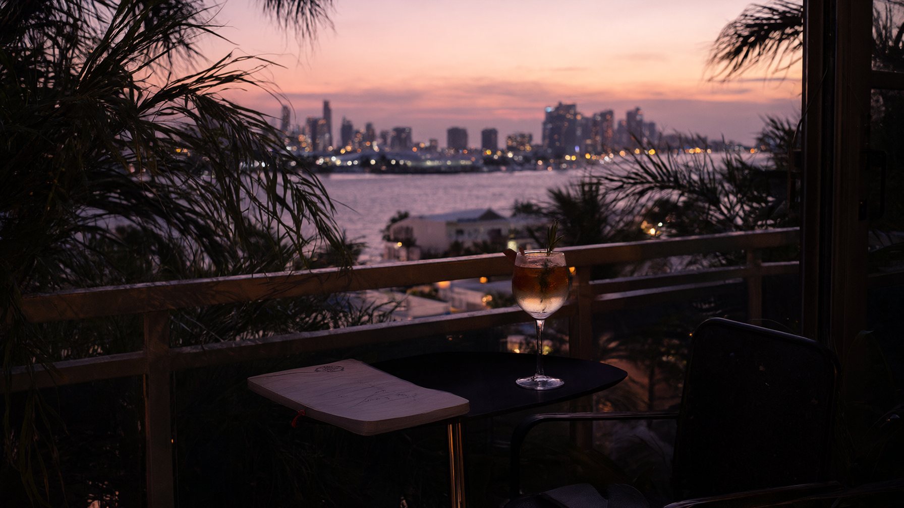Miami at dusk from a high balcony, palms against a pink sky
